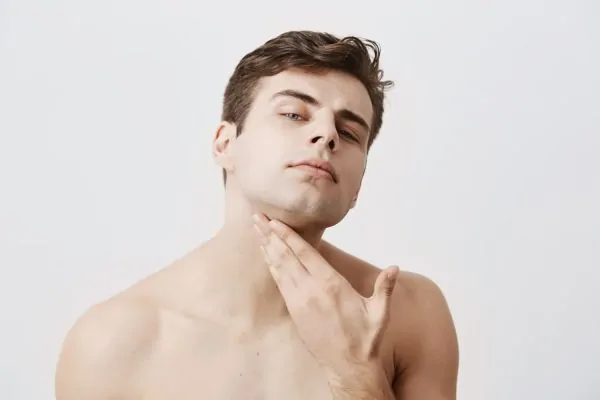 Man touching his jawline and neck area, demonstrating facial structure assessment for age-related jawline changes