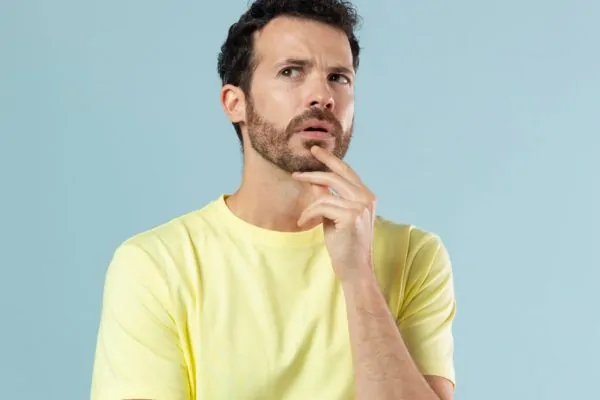 Man with a concerned expression wondering if adding skin tightening to his liposuction surgery will extend his recovery time
