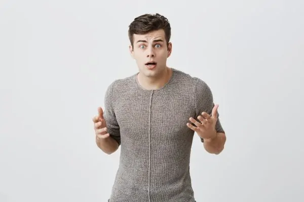 Man with a surprised and concerned expression gesturing with both hands, representing common patient questions and uncertainties about what to expect during neck liposuction recovery