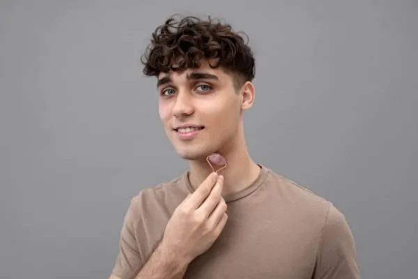 Man with facial roller showing jawline enhancement treatment area