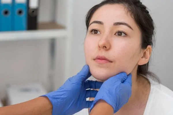 Medical professional evaluating jawline for dermal filler safety