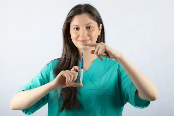 Medical professional holding dermal filler syringe demonstrating safe injection techniques for minimizing risks