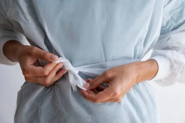 Patient in hospital gown preparing for combined hernia repair and abdominoplasty procedure with plastic surgeon
