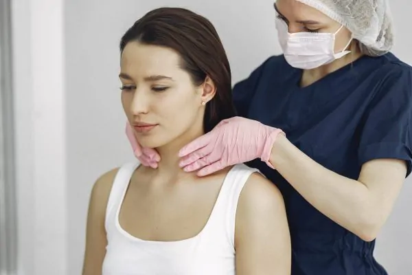 Practitioner evaluating patient's jawline during filler treatment process