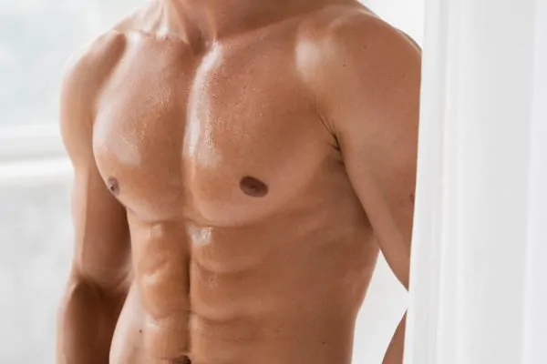 Sculpted male torso with defined six-pack abs and toned chest showcasing results achievable through popular liposuction techniques
