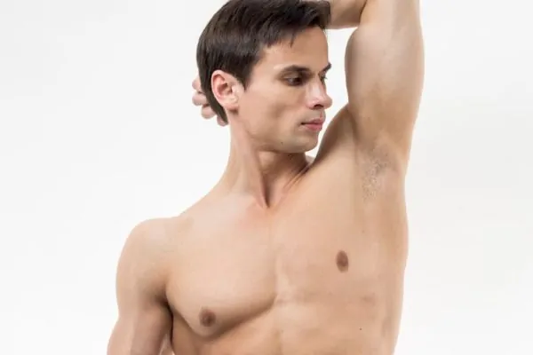 Shirtless man lifting his arm to expose his underarm area, illustrating the treatment zone for different types of underarm Botox procedures.