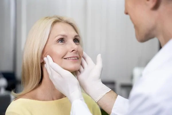 Surgeon holding patient face for botox procedure