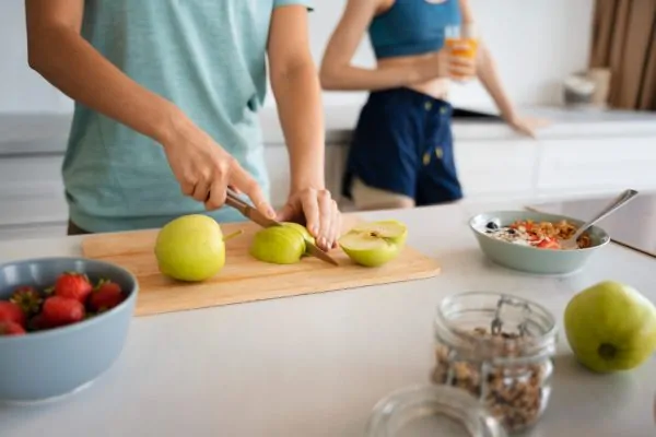 Woman slicing fresh apples for nutritious breakfast supporting liposuction recovery and long-term results