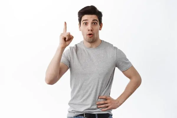 Young man pointing upward with a surprised expression, illustrating the 'aha moment' of discovering neck liposuction as a solution for improving jawline definition and reducing submental fat.