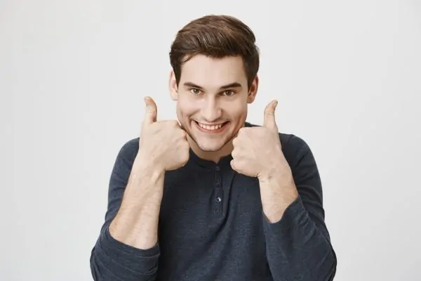 cheerful man showing thumbs-up in approval