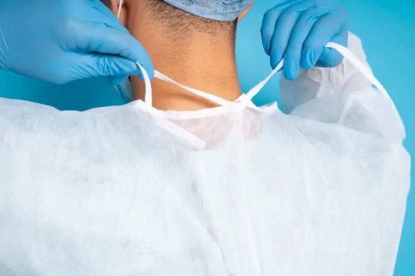 Doctor tying medical gown side view