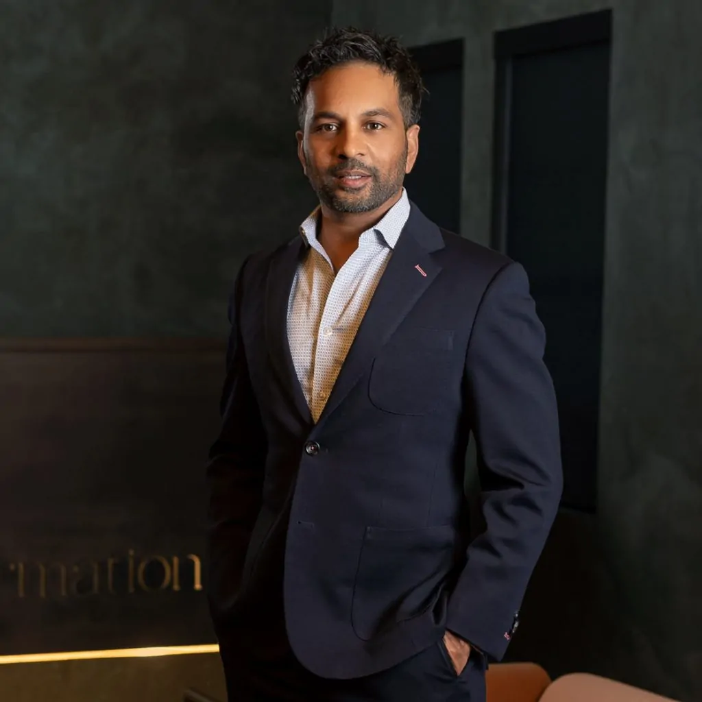 Dr. Gopal Grandhige posing inside the Formation Clinic in a dark suit.