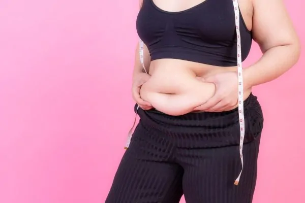 Overweight squeeze belly fat with measure tape