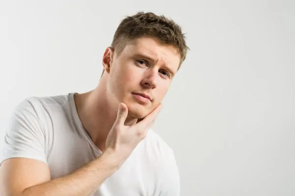 Portrait of a young man touching his Jawline