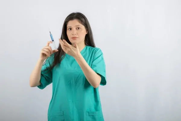 Portrait of female surgeon holding syringe