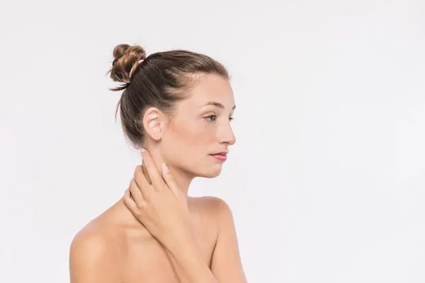 Pretty woman with bare shoulders touching neck