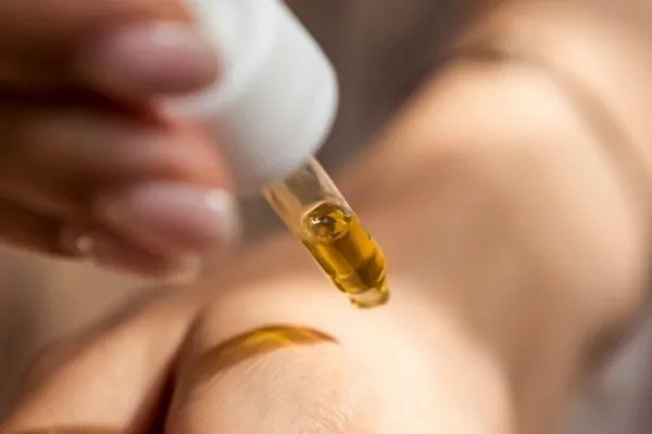 Hand putting drop of medicine into skin