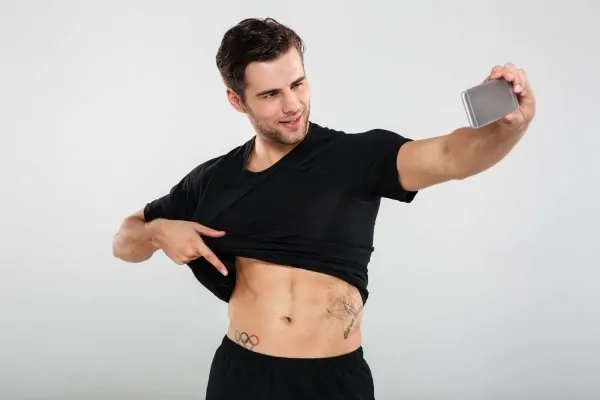 smiling charming man pulling his shirt up