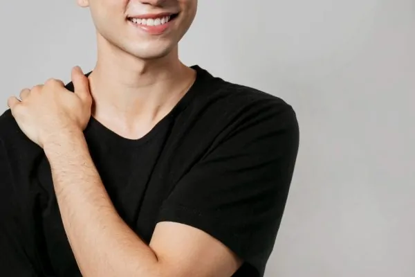 smiling man holding shoulder