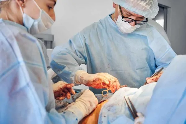 Surgeon and assistant conducting tummy tuck surgery