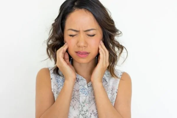 woman frowning and touching swollen cheeks