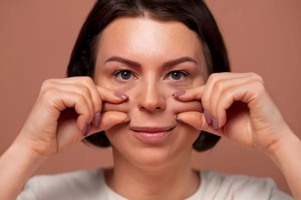 woman pinching her cheeks