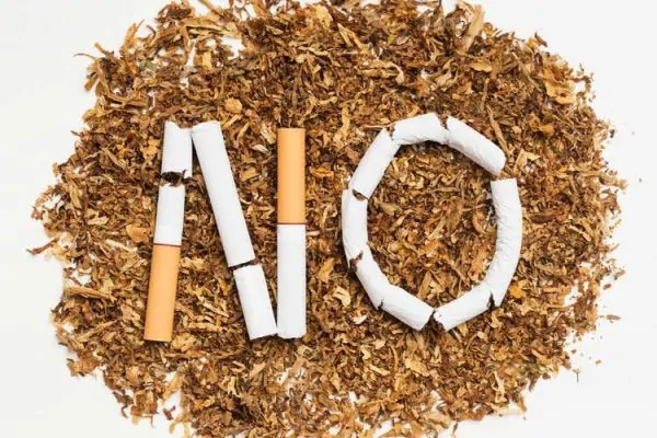 Word no made from broken cigarette over tobacco