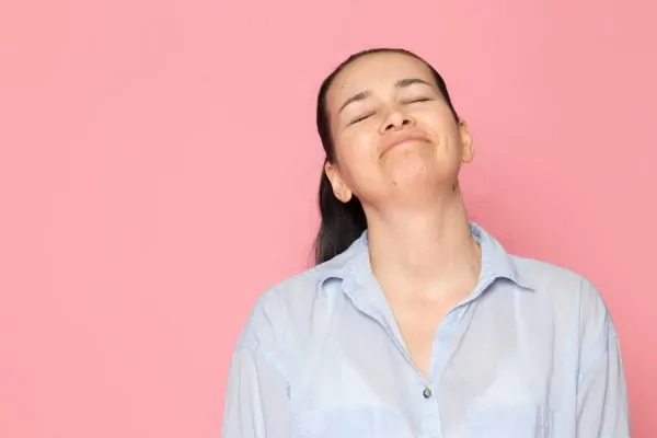 Young female showing her neck in blue shirt posing