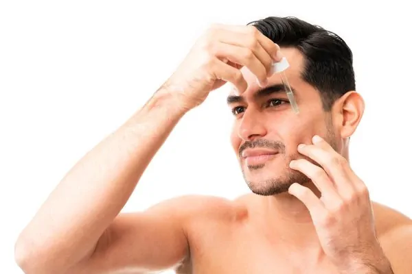 young man applying a drop facial maintenance